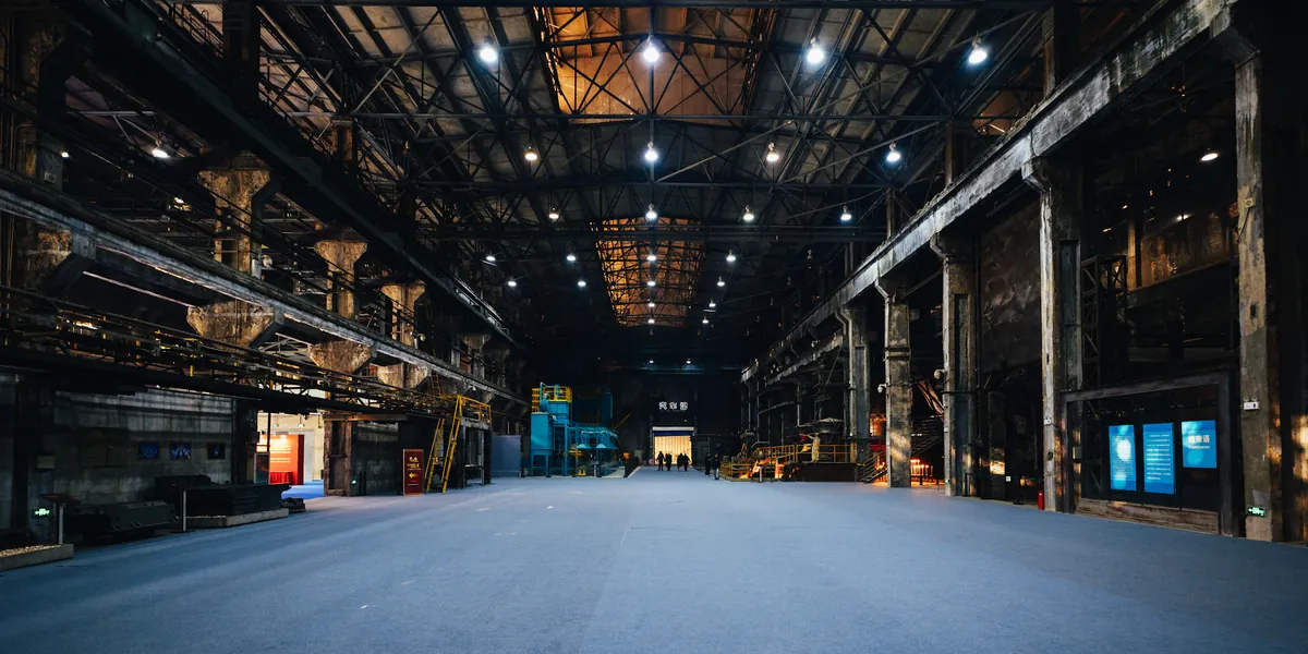 Eine lange Industriehalle mit Deckenbeleuchtung